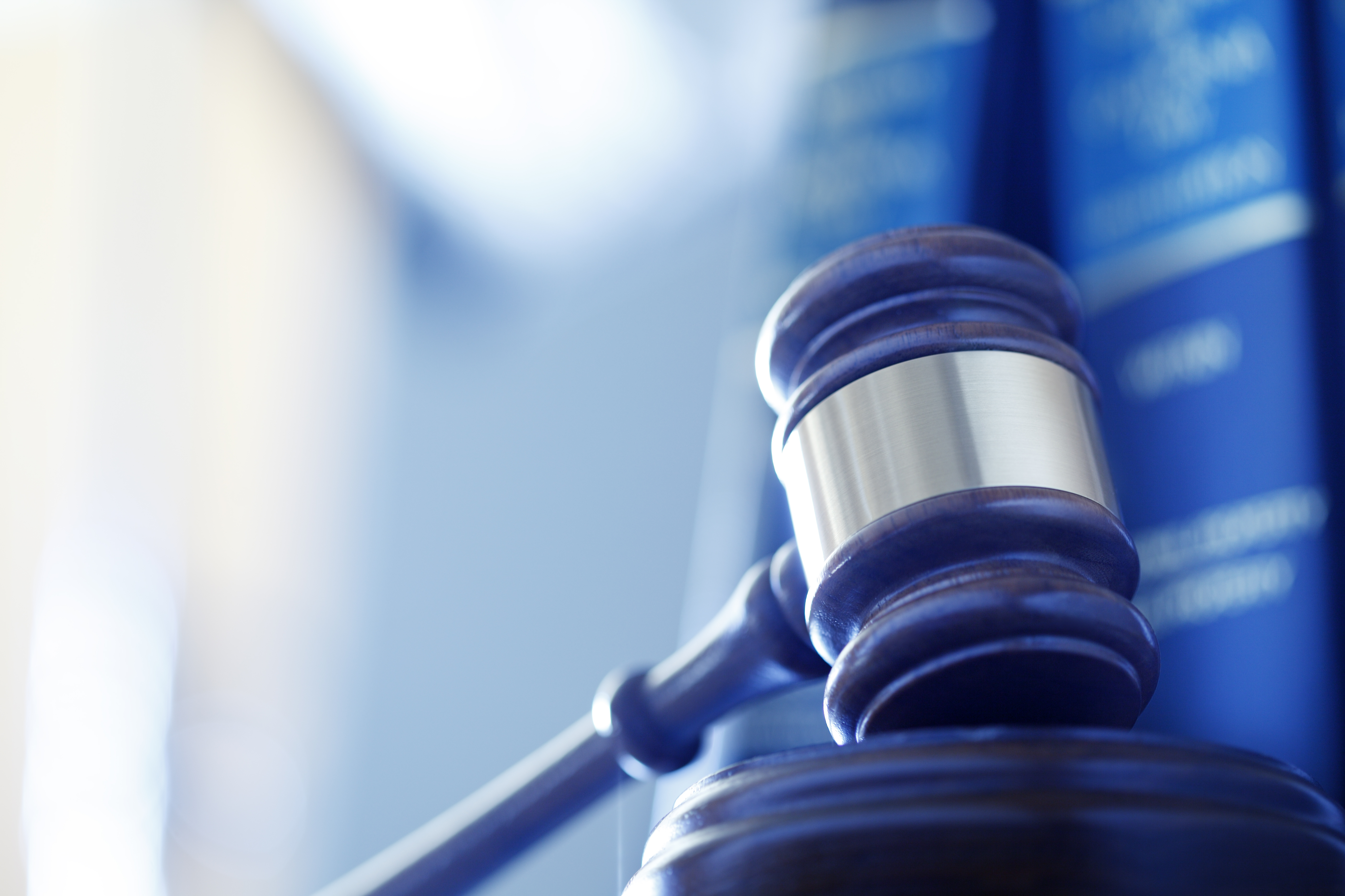 Close-up of a judge’s gavel with law books in the background.