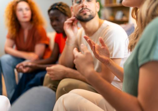 A small group sits in a circle having a discussion.