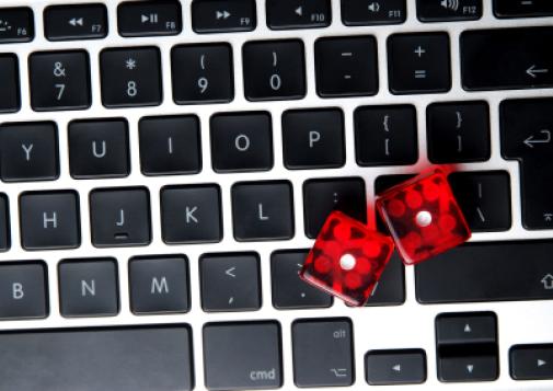 A pair of dice on a laptop keyboard.