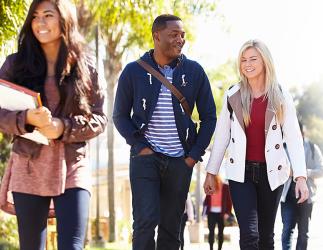 Two students walking on a campus, appearing to be having a pleasant time