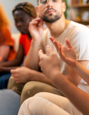 A small group sits in a circle having a discussion.