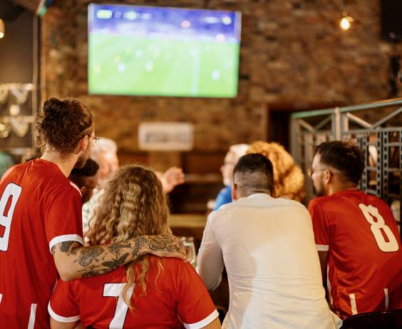 Group of fans watching sports in a bar.