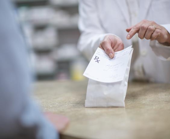 pharmacien tenant un médicament avec une ordonnance