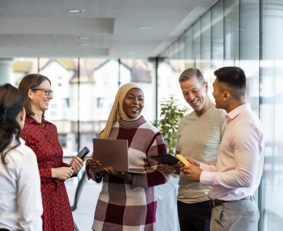 Groupe d'employés discutant au travail.