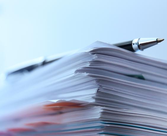 Un stylo posé sur une pile de papiers.
