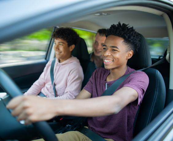 Jeune au volant d'une voiture.