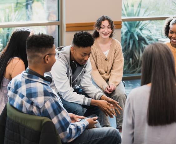 Youth sitting in a circle having a conversation.